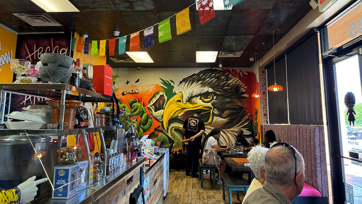 The dining room with a hand-painted eagle mural and papel picado overhead