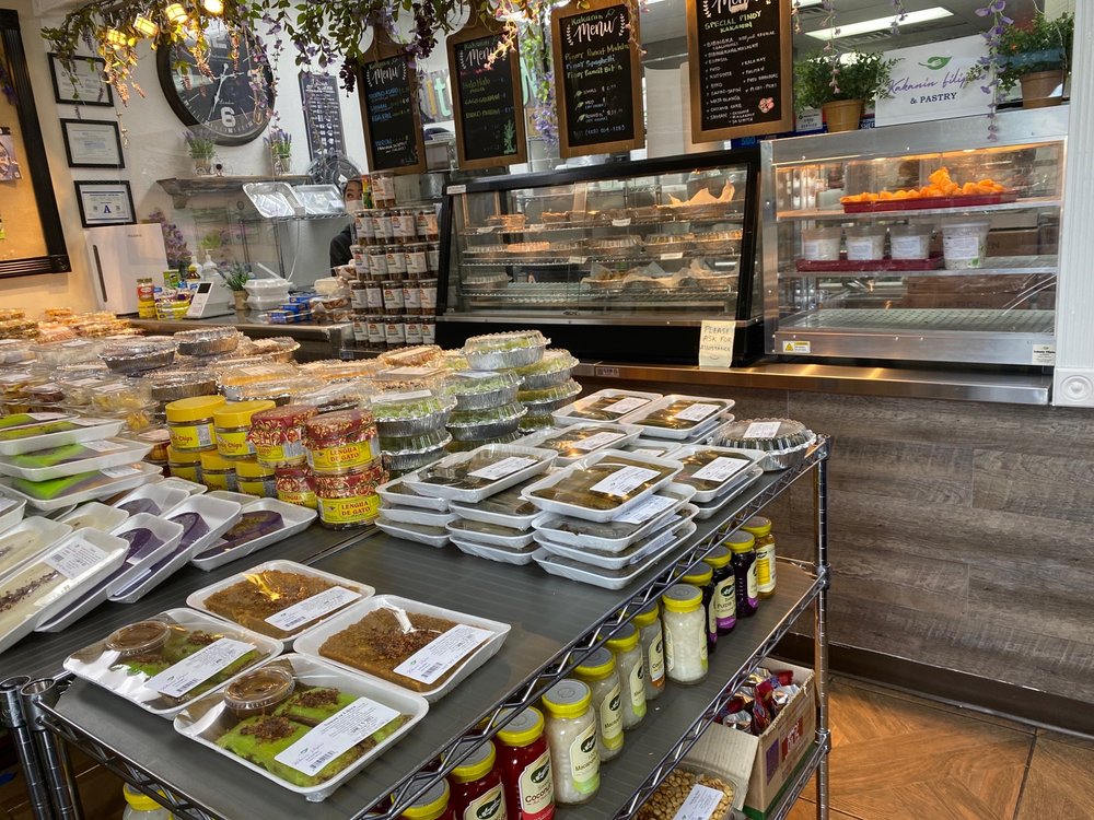 Inside the shop: shelves of packed Filipino snacks and pasalubong goods in front of the bakery counter