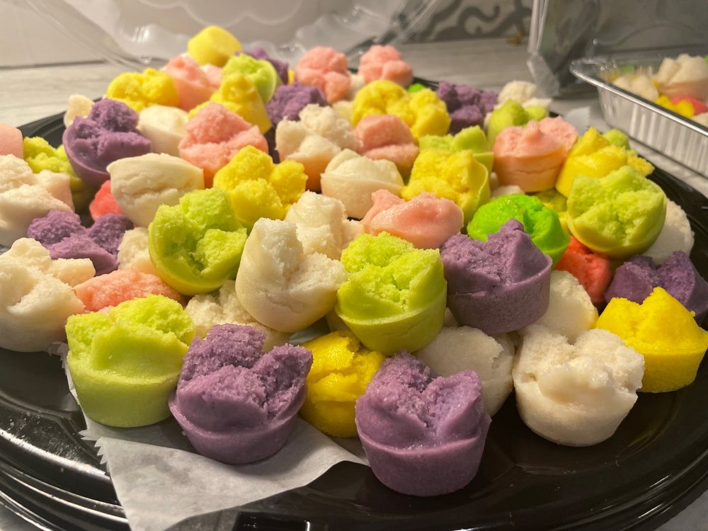 A platter of steamed rice cakes in ube purple, pandan green, mango yellow and pink