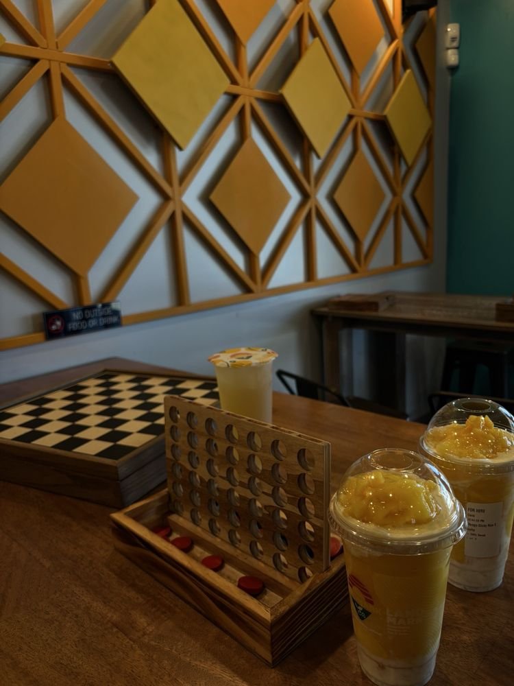 Connect Four and a chess board set up on a cafe table with Landmark Tea drinks