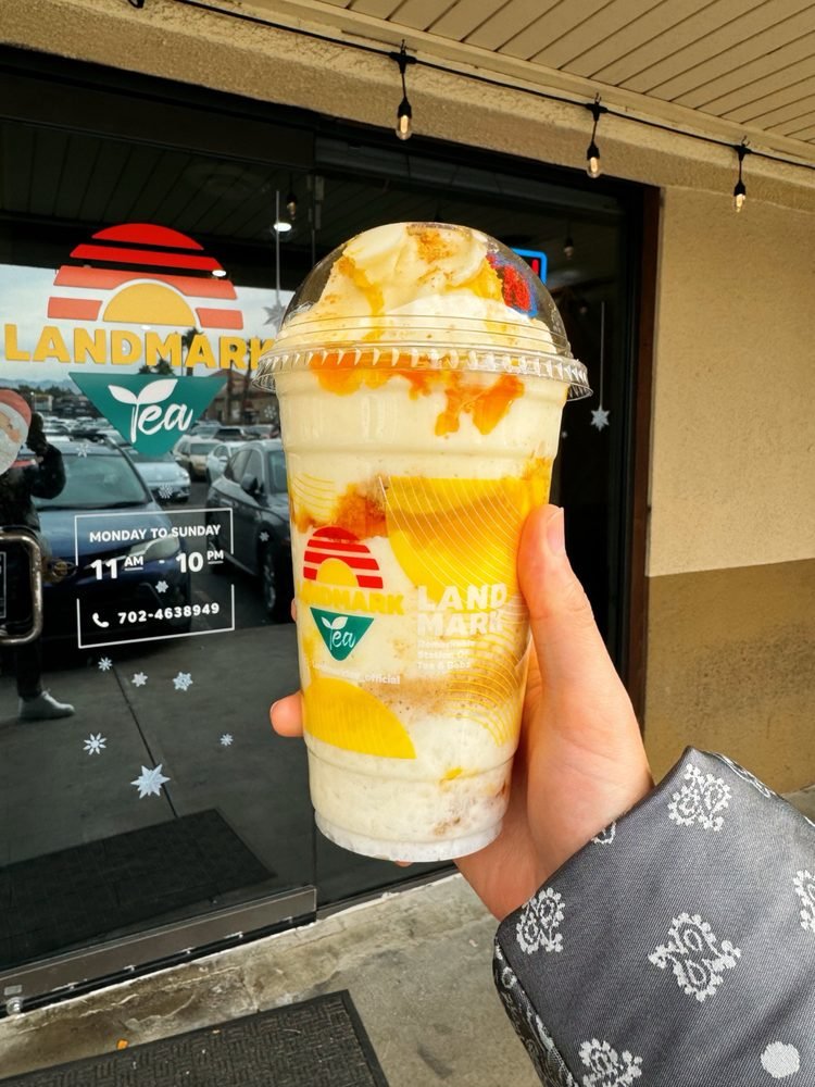 Mango Cheesecake frappe held up outside the Landmark Tea storefront