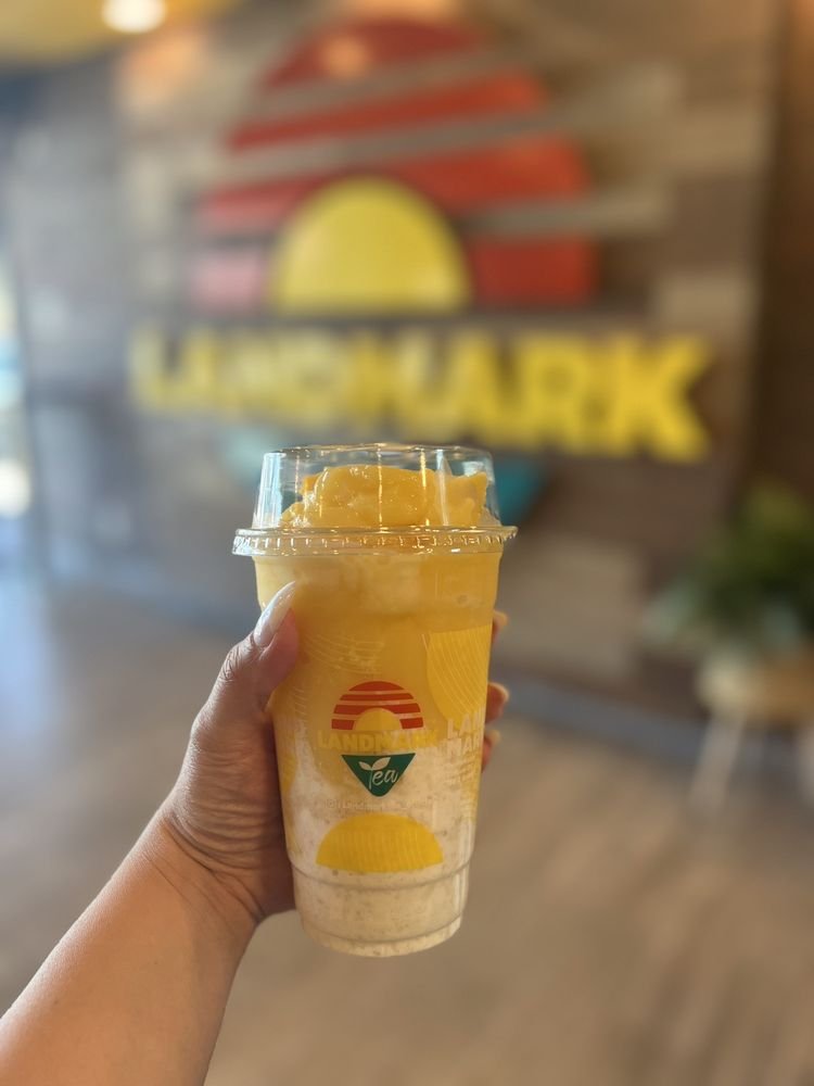 Mango Sticky Rice Slushy held in front of the Landmark Tea logo