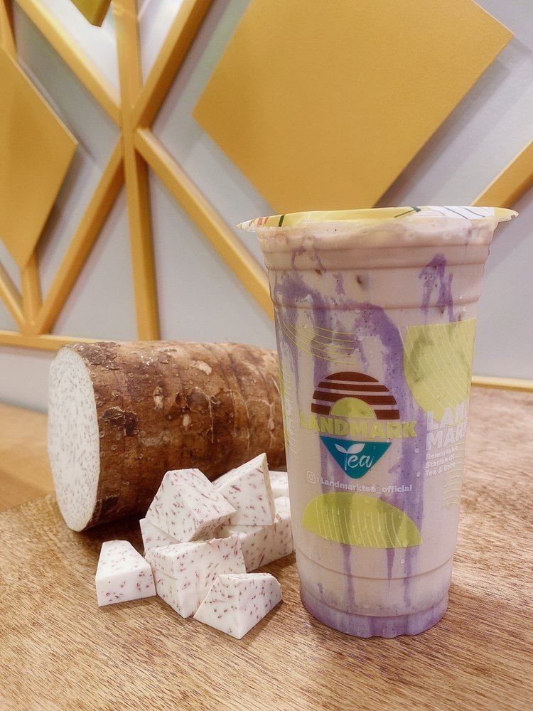 Purple Taro Lava milk tea beside a piece of fresh taro