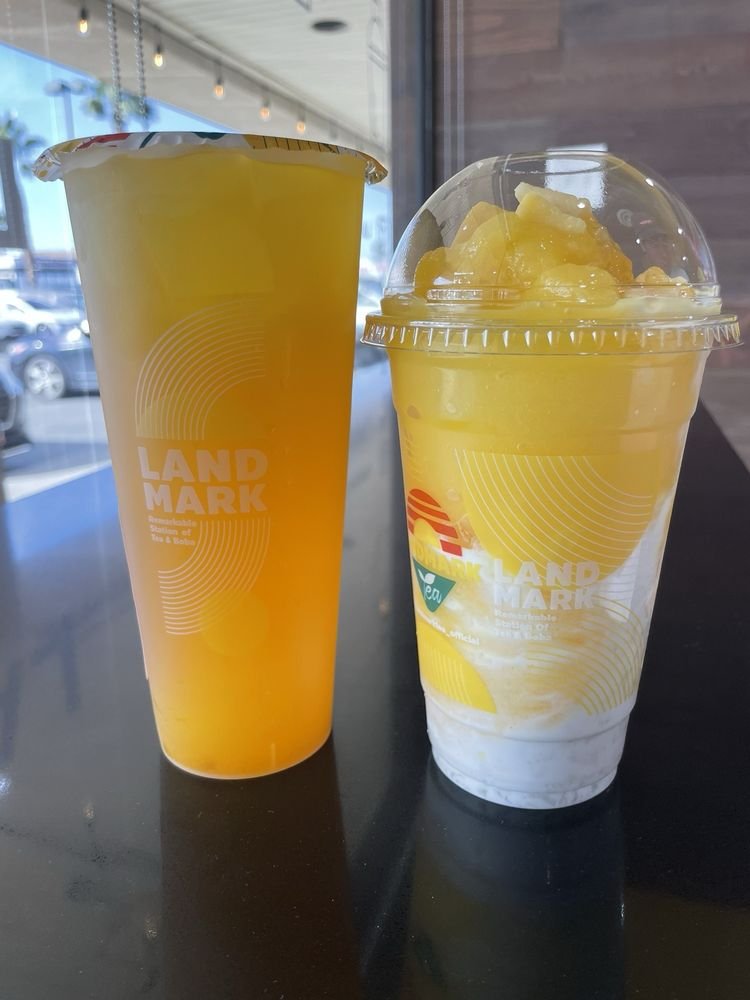 White Peach Mango fruit tea next to a mango slushy
