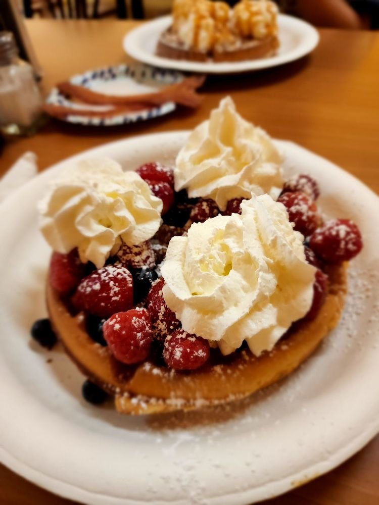 Blueberry waffle topped with berries and whipped cream