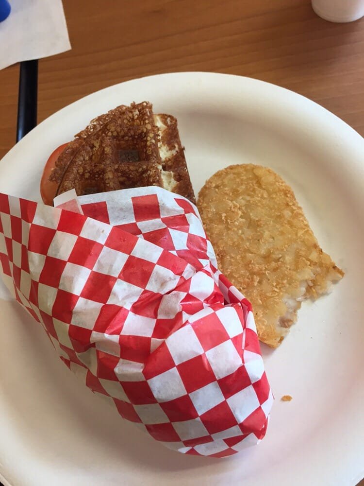 Chicken waffle sandwich with a hash brown on the side